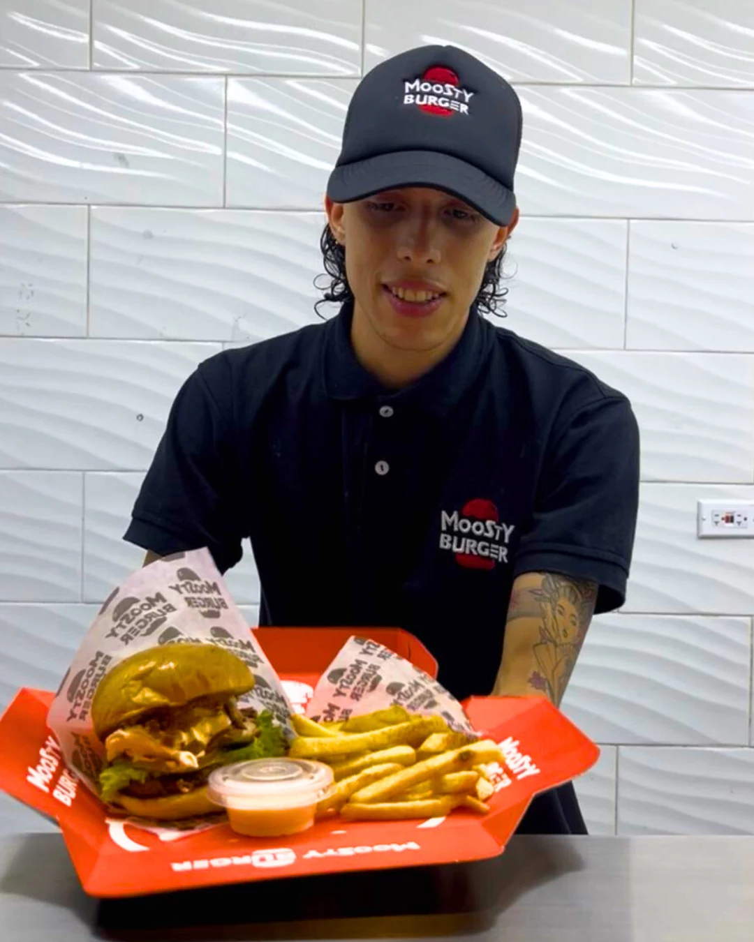 moosty-burguer-destacada-caja-entregando-pedido-empaques-kreat-up Caja para hamburguesas de cartón kraft personalizada con diseño gráfico, ideal para alimentos, diseñada por KreatUp.