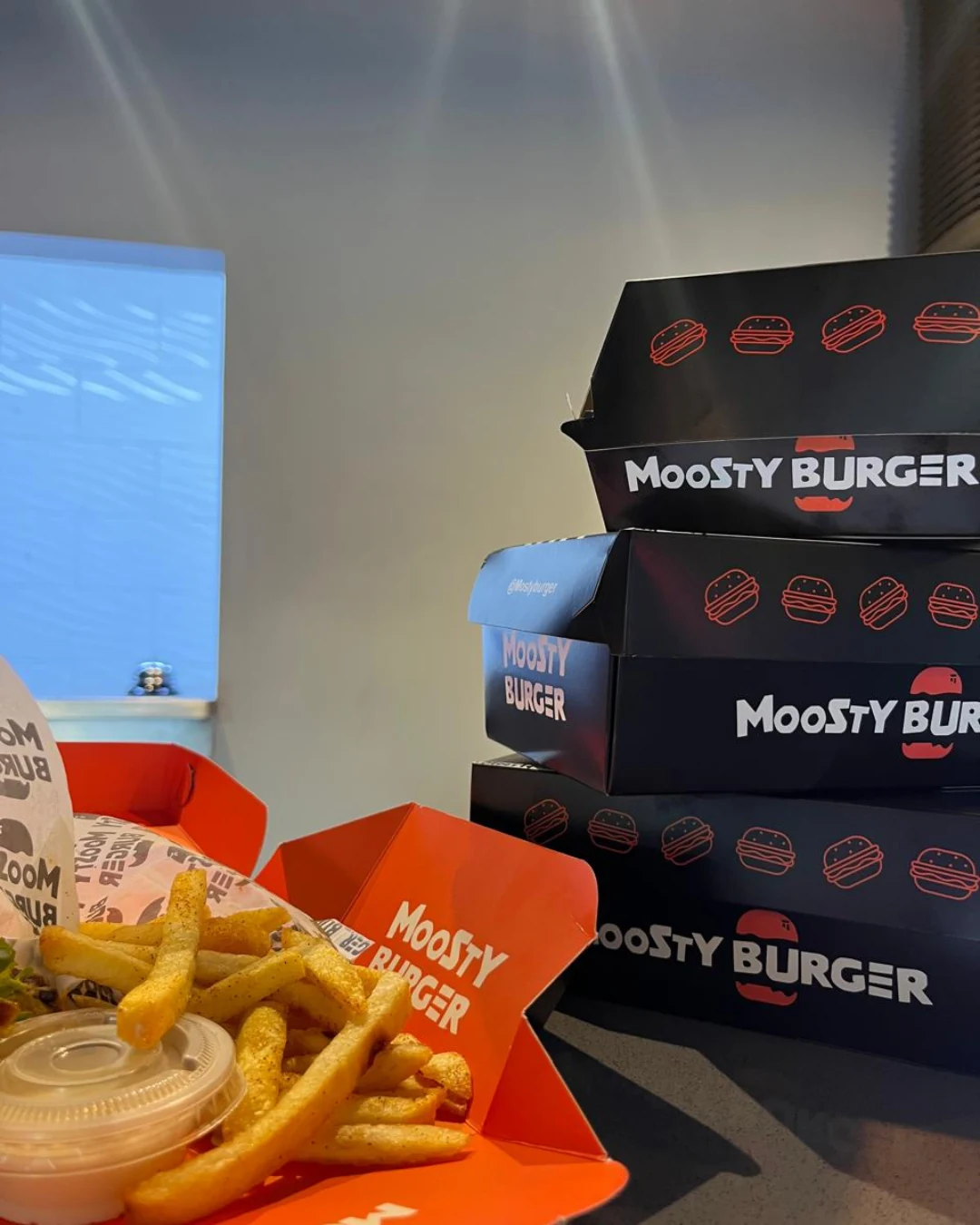 moosty-burguer-destacada-caja-hamburguesa-empaques-kreat-up-3 Cajas para hamburguesas Moosty Burger en cartón negro y rojo, diseño personalizado por KreatUp para alimentos.