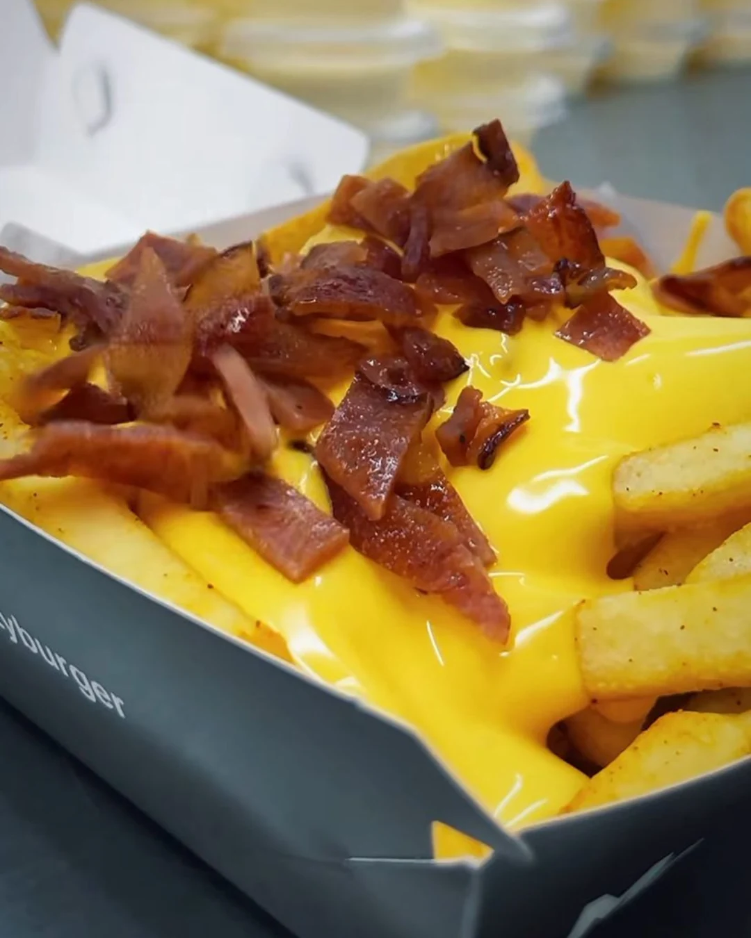 moosty-burguer-destacada-caja-papas-fritas-empaques-kreat-up Bandeja de cartón kraft personalizada para alimentos con diseño gráfico, diseñada por KreatUp para Moosty Burger.